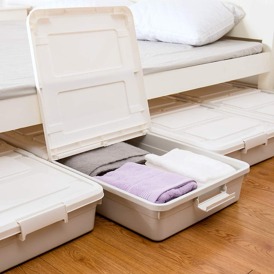 Plastic underbed storage containers holding folded towels and linens