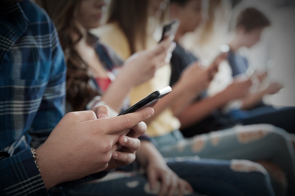  Group of people focused on smartphones, symbolizing digital distraction and social media addiction.