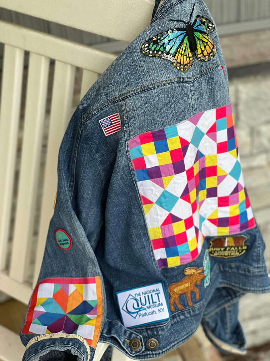 Upcycled denim jacket with colorful quilt blocks and patches.