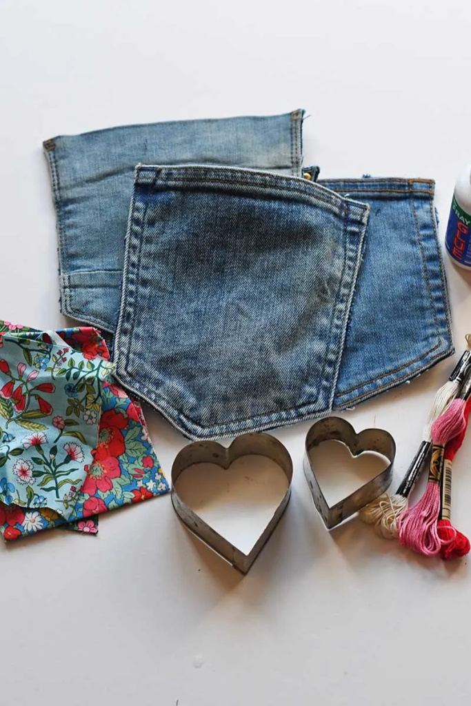 Jean pockets laid out on a table alongside materials in preparation for upcycling