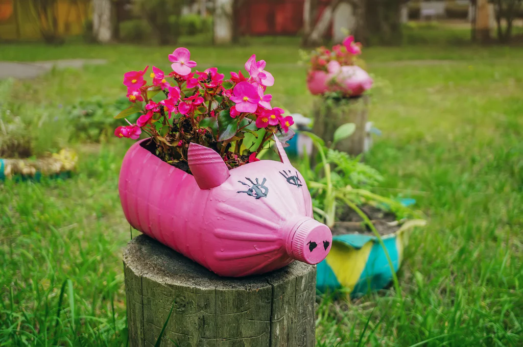 A planter made out of a large bottle painted as a pink pig.