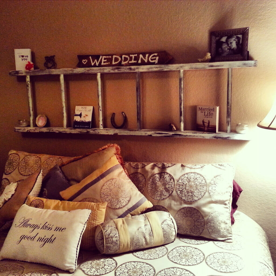 Rustic ladder wall shelf above bed with wedding decor and framed photos