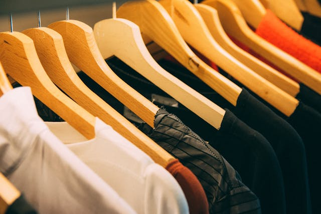 A close up of clothes hangers with clothing hung up.