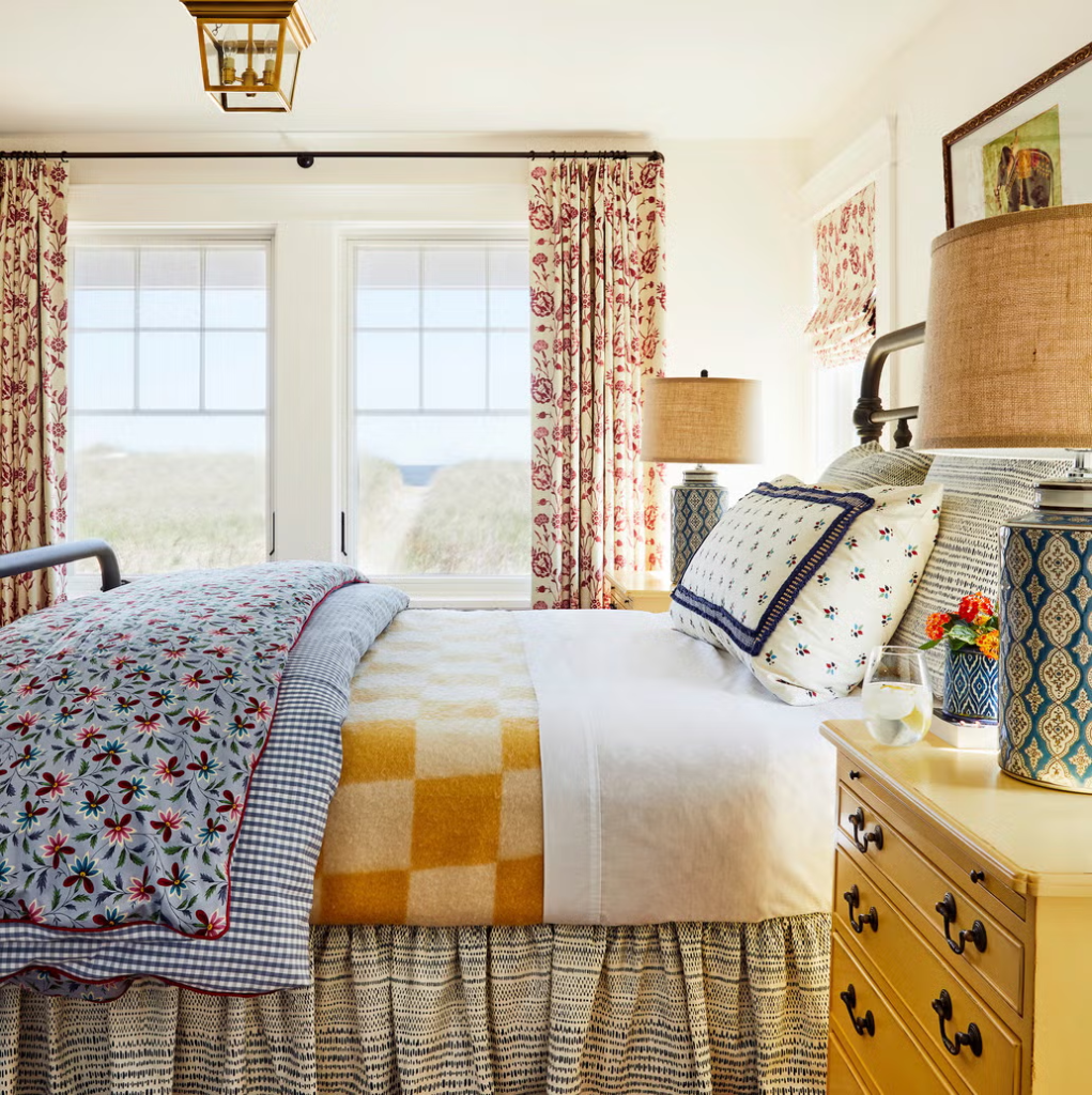 A colorful bedroom of difering linens and fabrics.