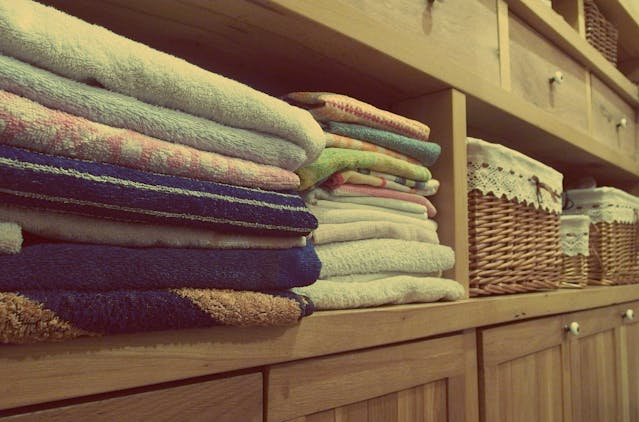 A rack of folded towels and other linens.
