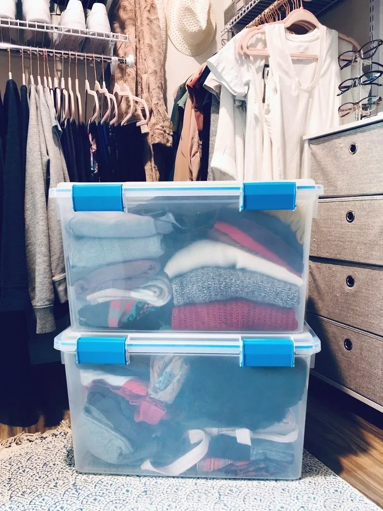 Plastic tupperware Containers of winter clothes ready to be stored away after winter.