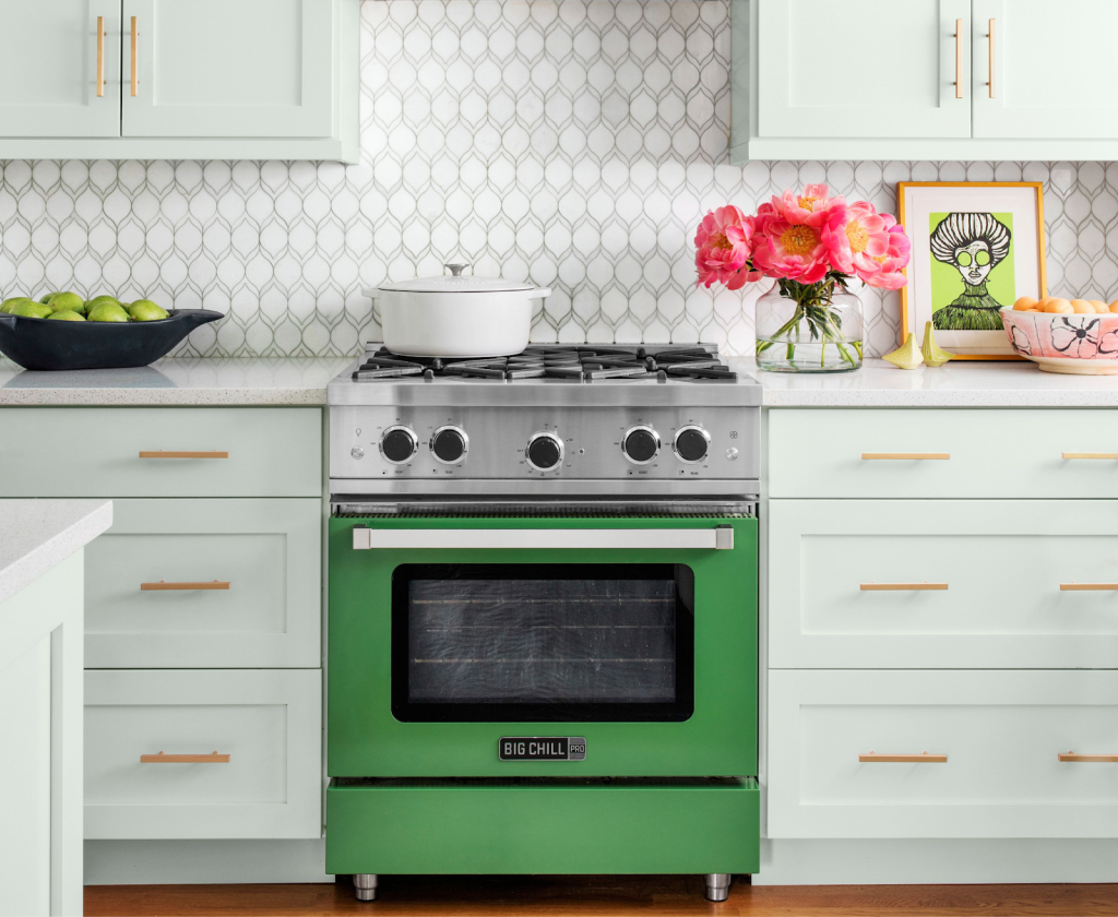 Mint green kitchen cabinets with patterned tile backsplash and vintage-style green gas range