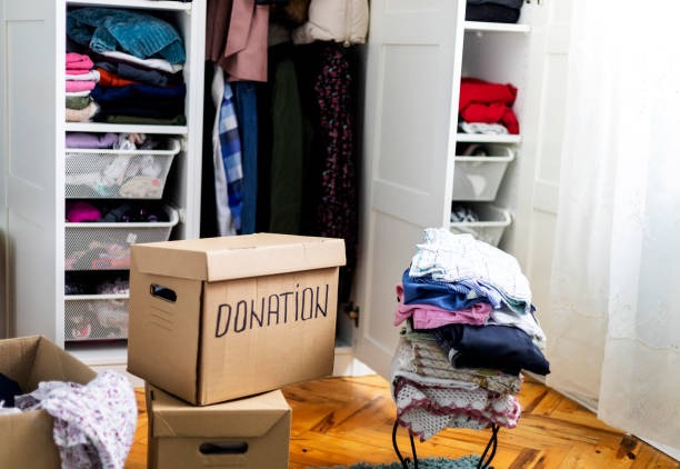 Clothing donation box placed in front of an organized closet after wardrobe cleanout