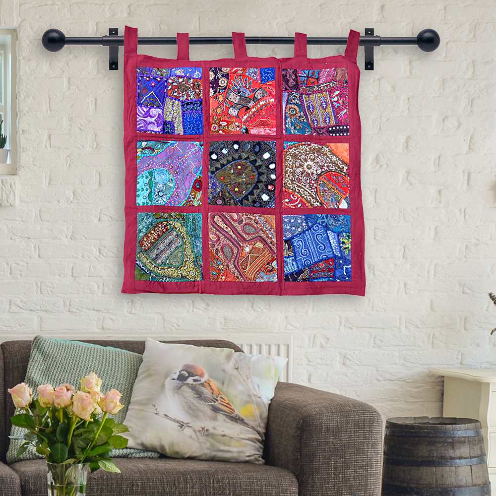 Patchwork textile wall hanging with vibrant handmade fabric squares above sofa