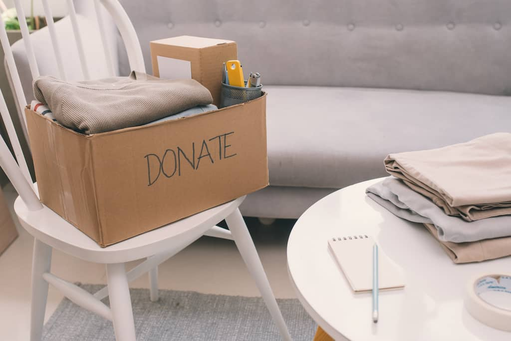 Donation box filled with folded clothes and household items for decluttering