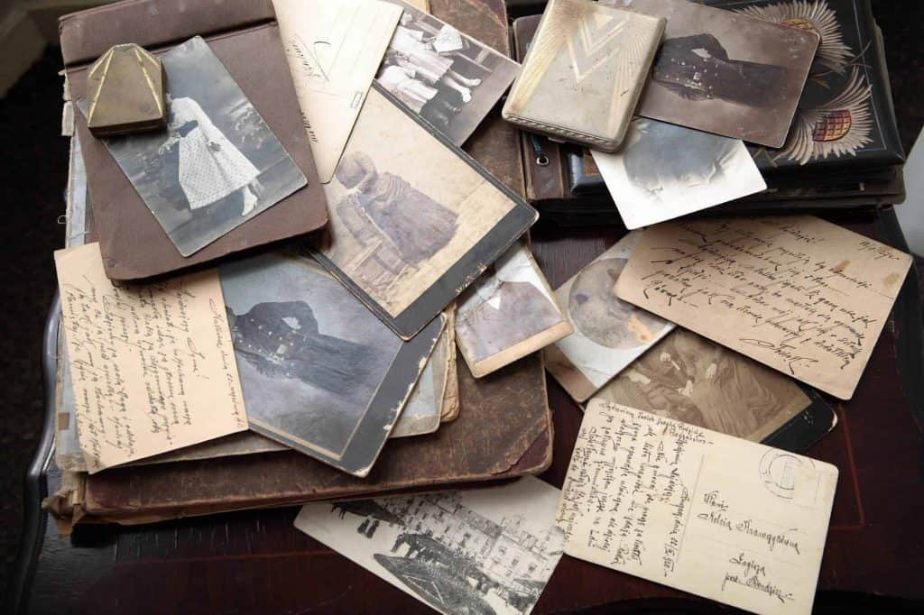 Collection of vintage photographs and handwritten letters spread across a wooden table