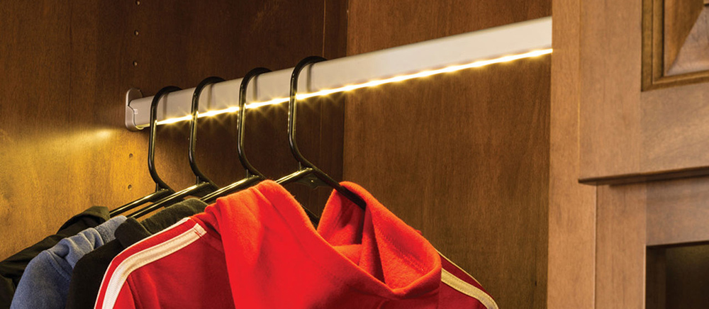 LED closet rod lighting installed above hanging clothes for modern wardrobe illumination