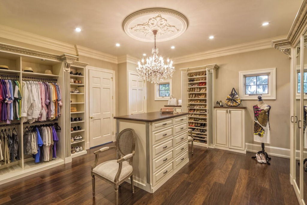 Luxury walk-in closet with center island, chandelier lighting, shoe shelves, and custom cabinetry
