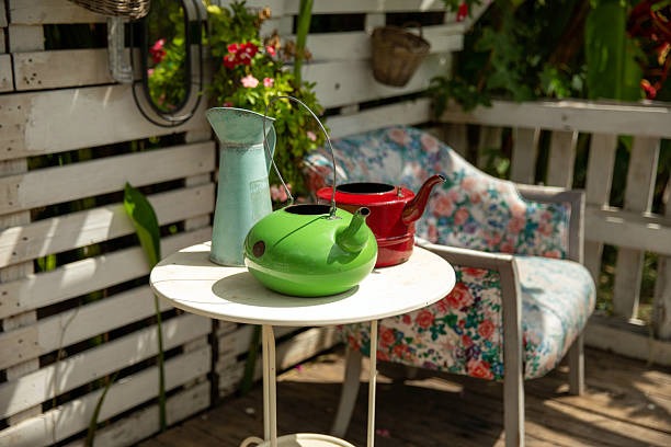 Repurposed watering cans used as affordable outdoor seasonal decor accents