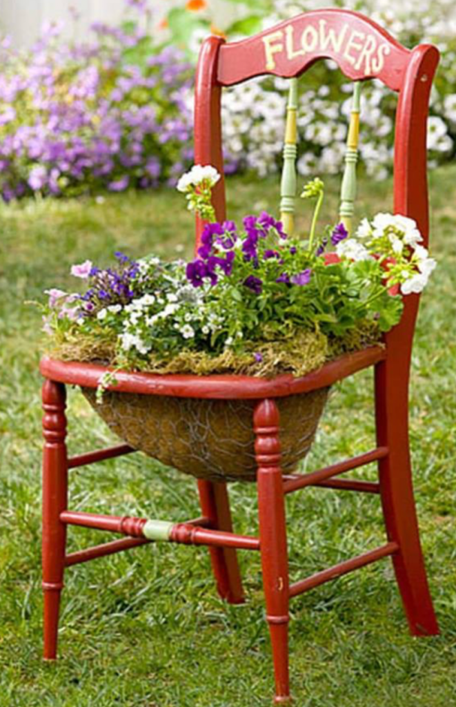 Upcycled wooden chair turned into decorative flower planter for creative garden display