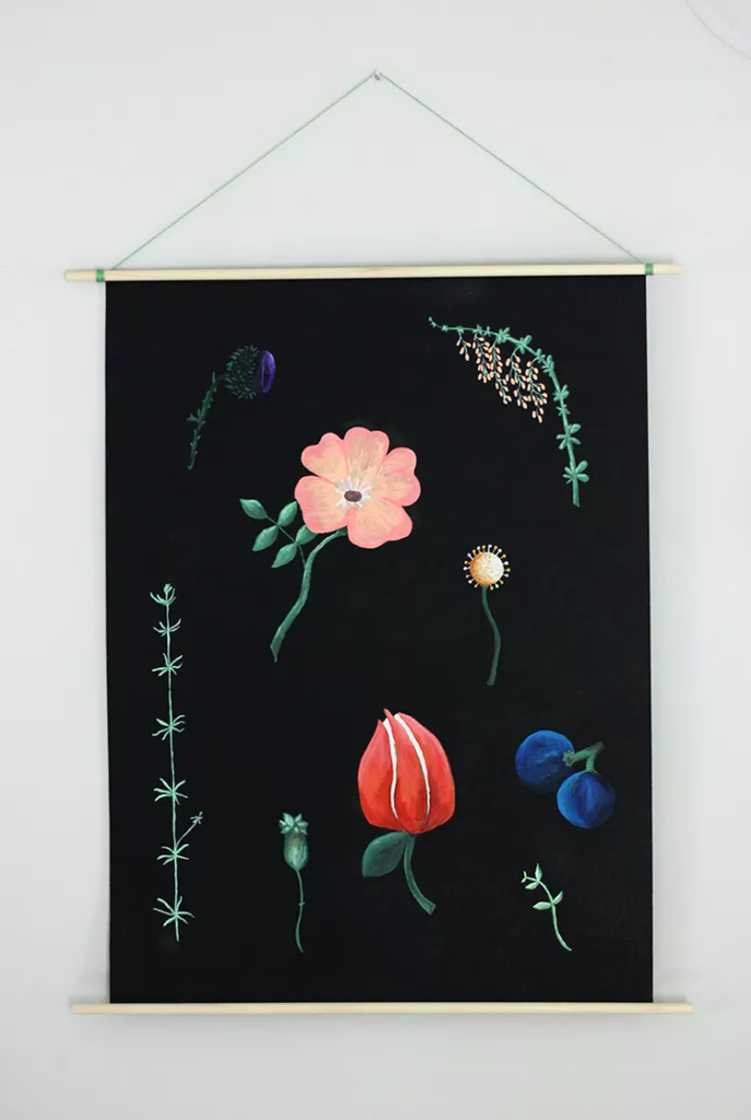Hand-painted botanical fabric wall hanging with floral illustrations on black background