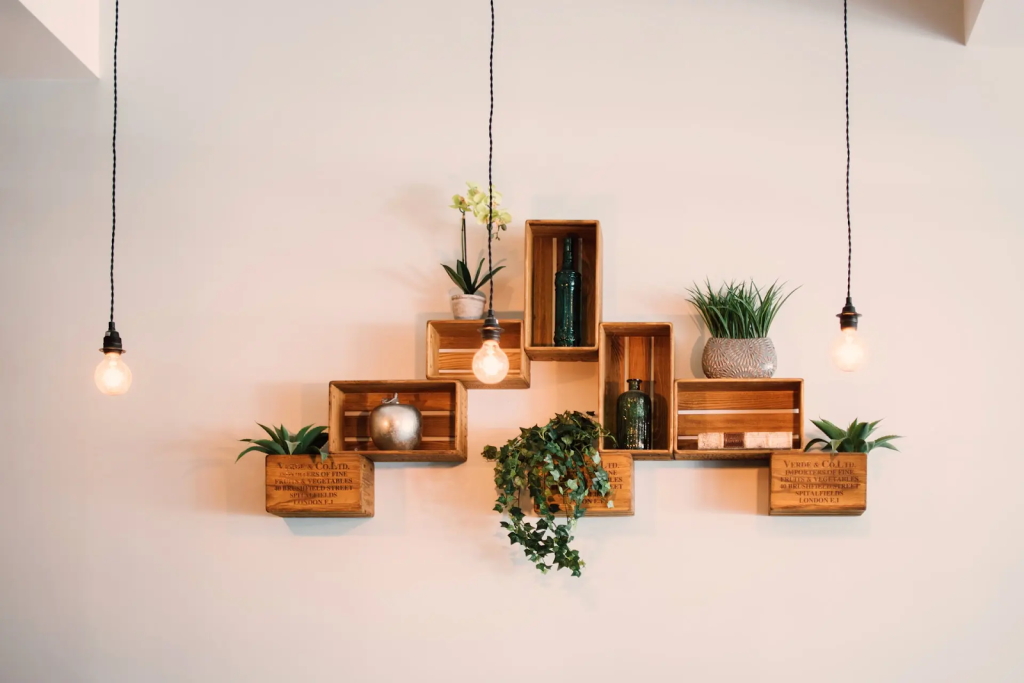 Rustic wooden crate wall shelves styled with plants, bottles, and hanging pendant lights
