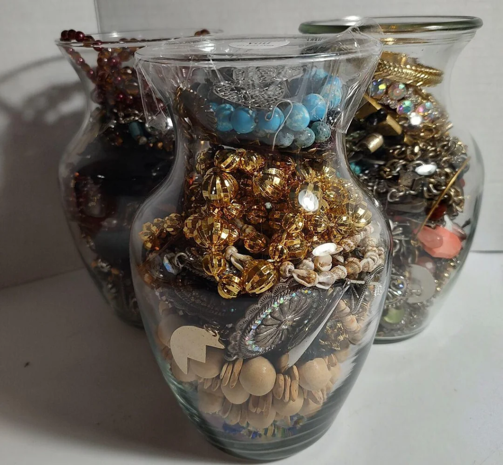 Glass jars filled with assorted jewelry, beads, and accessories for organized craft storage