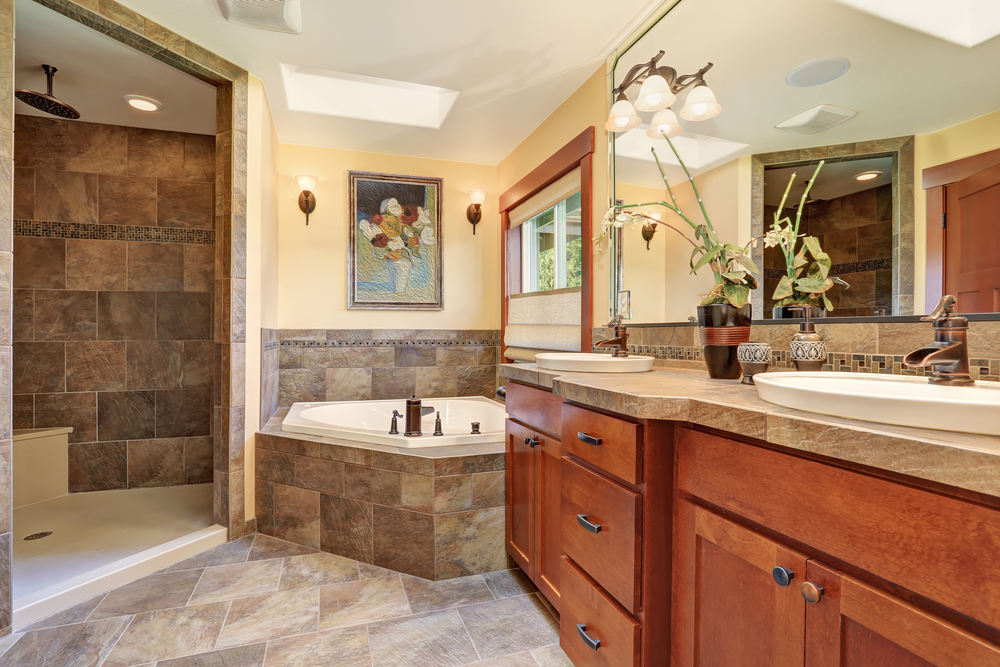 Traditional bathroom interior with wooden cabinets, tiled shower, soaking bathtub, and double sink vanity