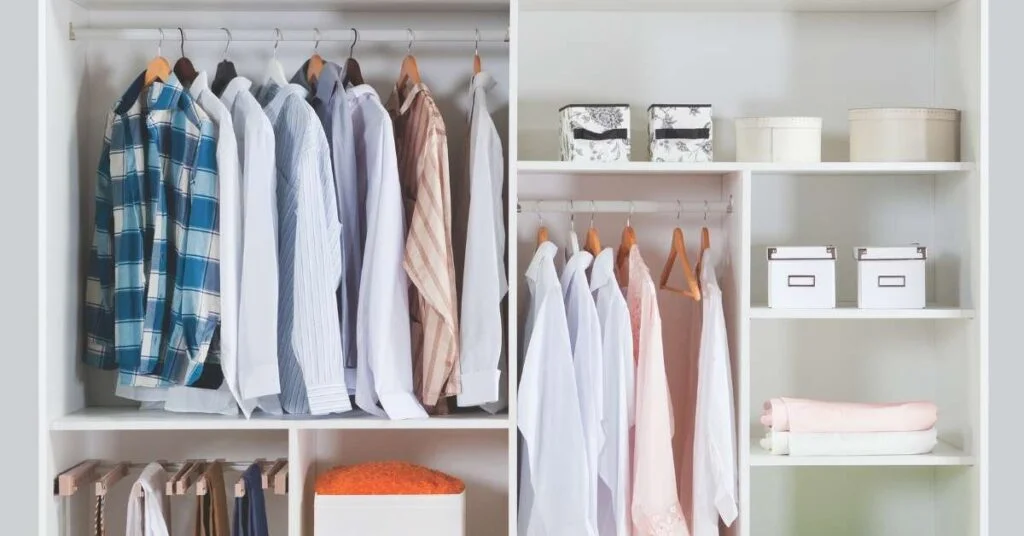 Minimalist wardrobe closet with neutral clothing, open shelves, and folded linens