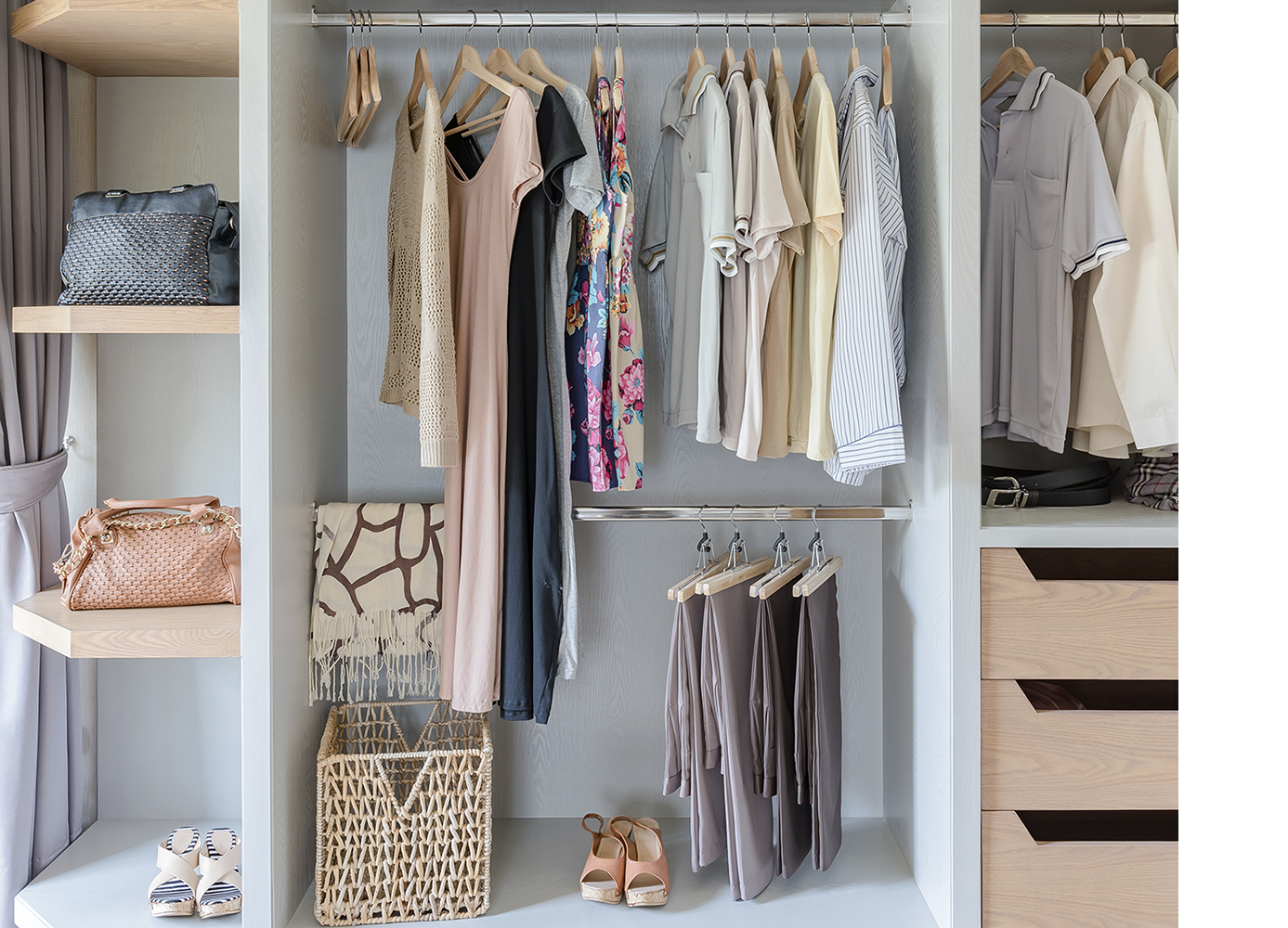 Organized walk-in closet with neatly arranged clothes, shelves, handbags, and shoe storage