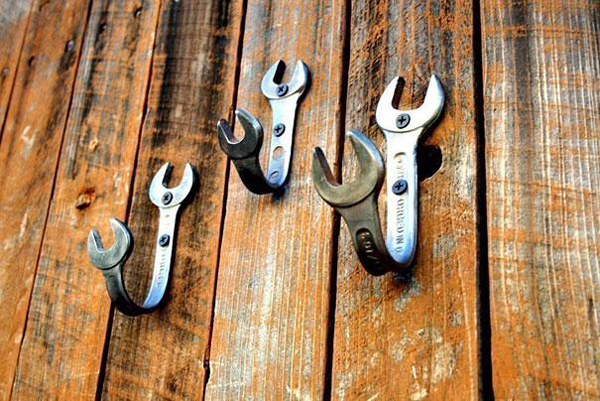 Wrenches turned into hooks on a wooden wall.