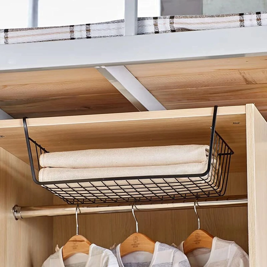 Under shelf wire basket organizer holding folded towels inside a wooden closet cabinet