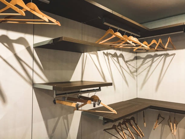 Empty walk-in closet with shelves and wooden hangers ready for clothing organization