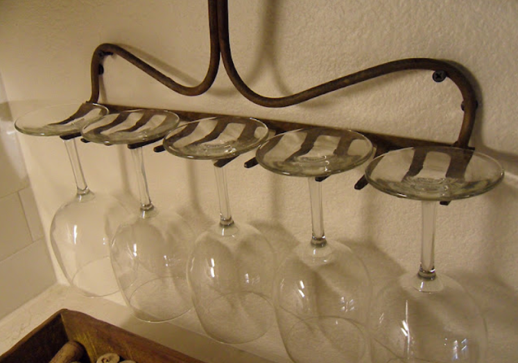 Rustic rake turned wine glass rack hanging form a wall.