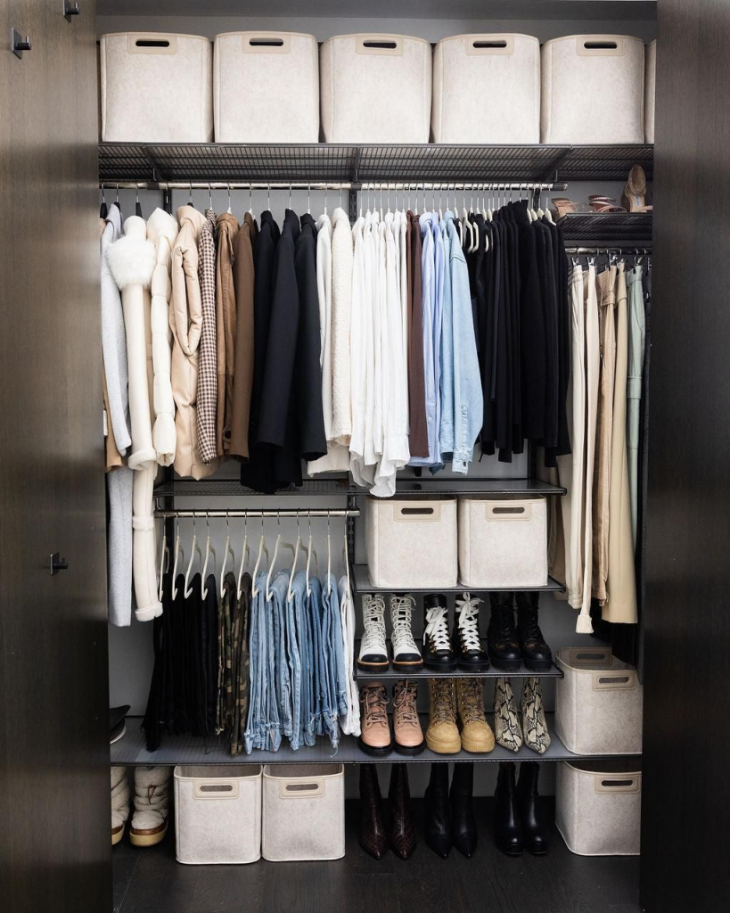 Modern closet organization system with hanging clothes, storage bins and shoe shelves