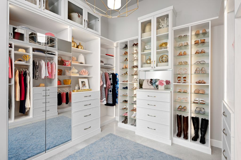 Modern walk-in closet with built-in shelves, hanging clothes, and central drawer storage system