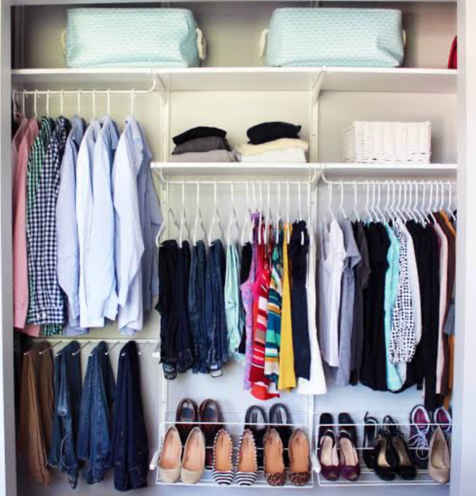 Well-organized closet with shirts, pants, and shoes arranged on shelves and hanging rods