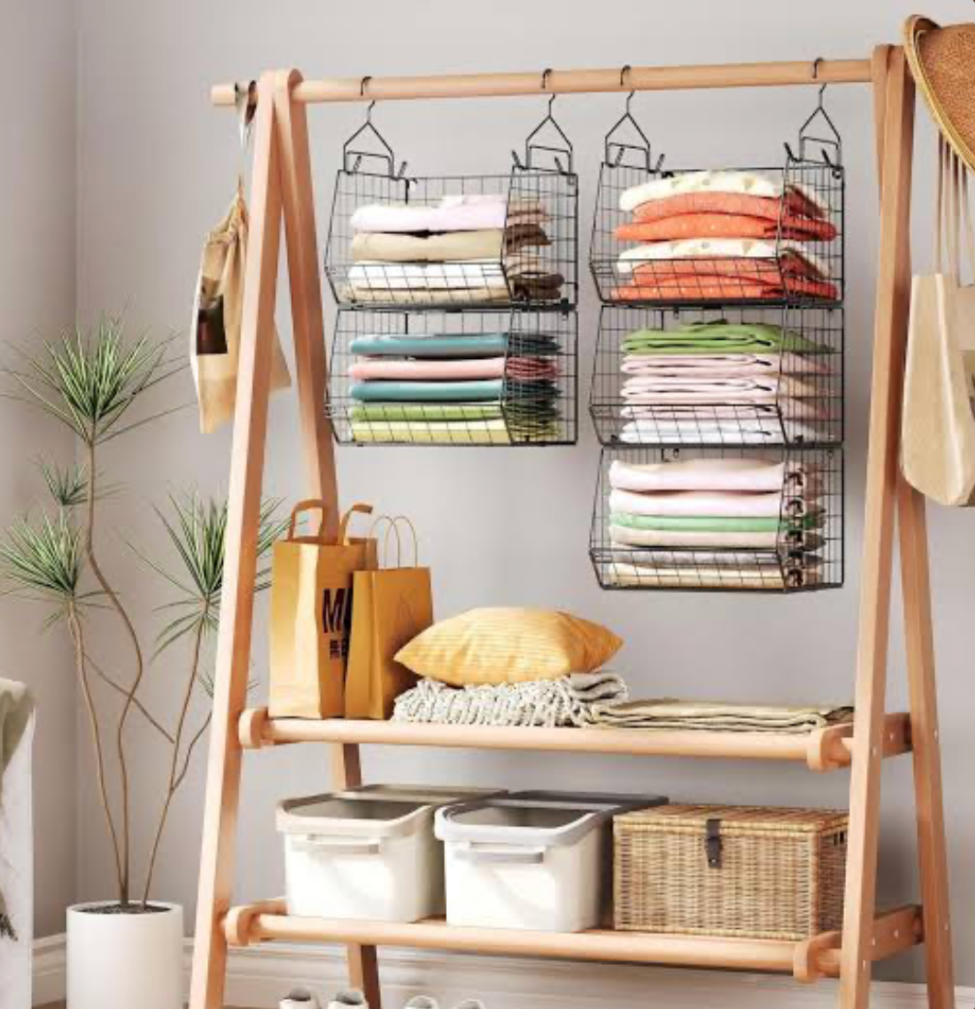 Open clothing rack with hanging wire baskets and folded clothes for small space storage