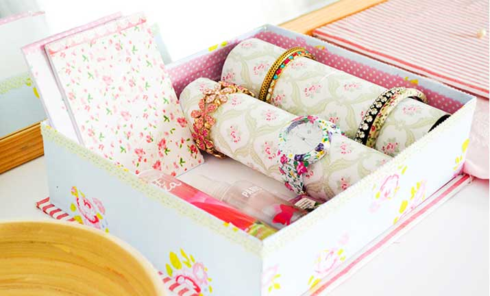 Floral decorative storage box with rolled accessories neatly organized inside