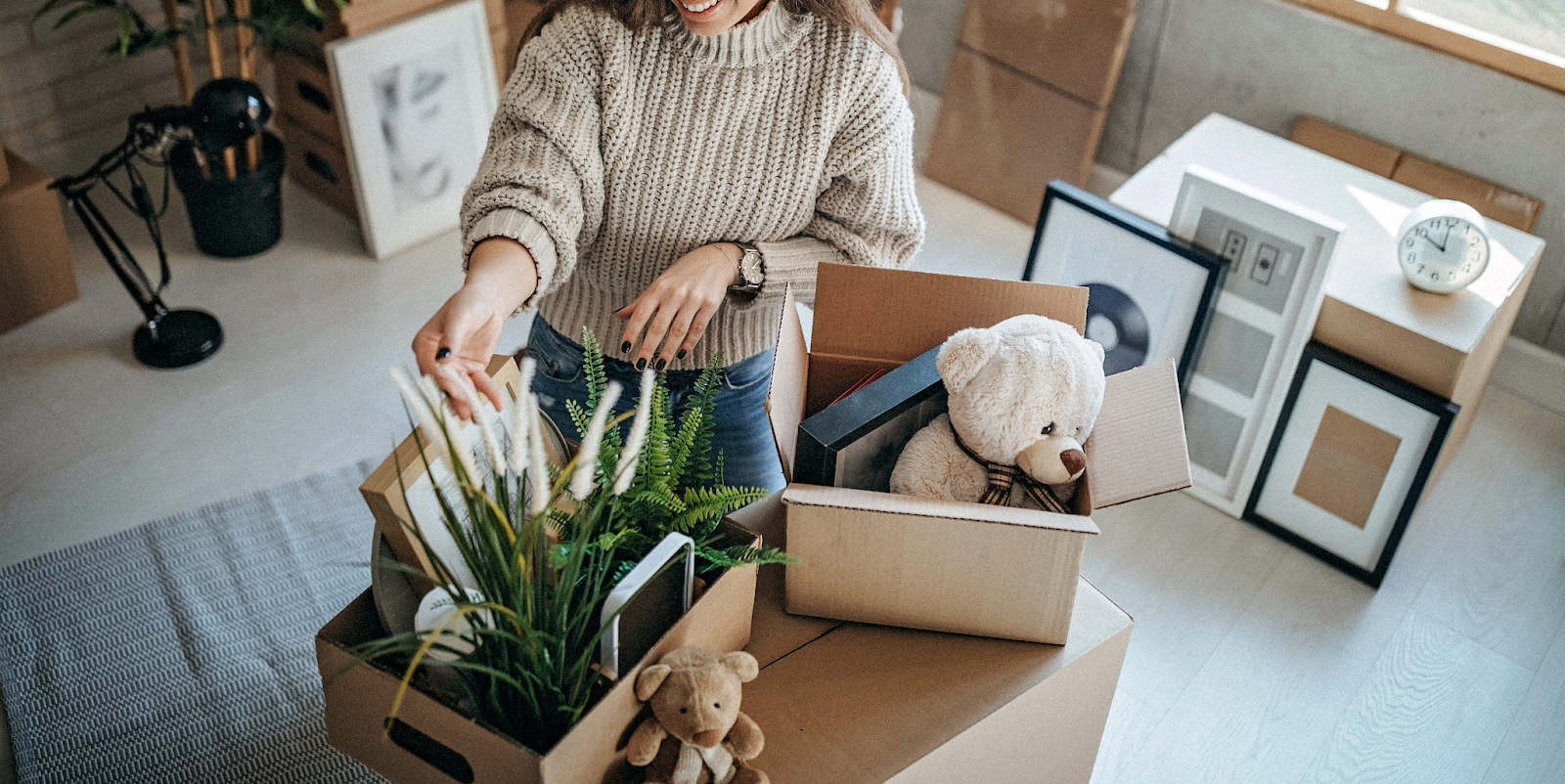 woman decluttering home and packing household items into boxes during organizing process