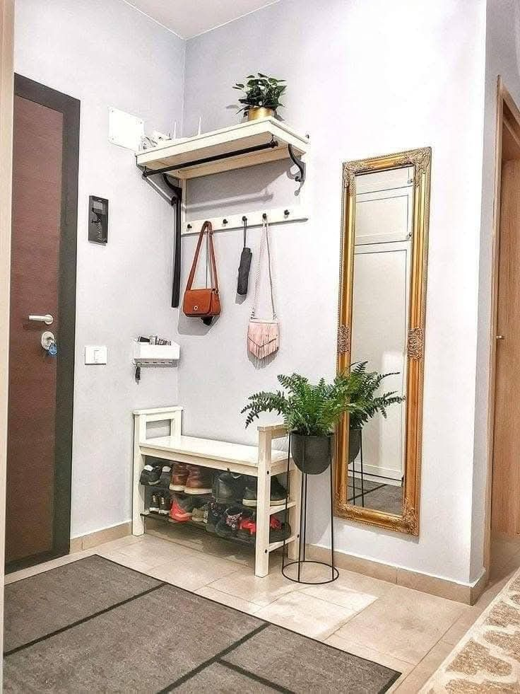 Small entryway design with wall shelf, hooks, shoe bench, full-length mirror, and plant for modern hallway decor