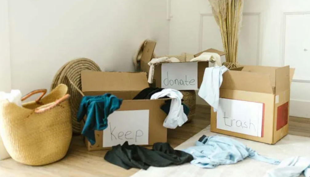 decluttering boxes labeled keep donate and trash for sorting clothes and household items