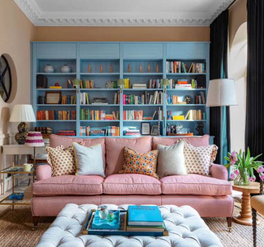 organized living room with styled bookshelves pink sofa and clutter free decor