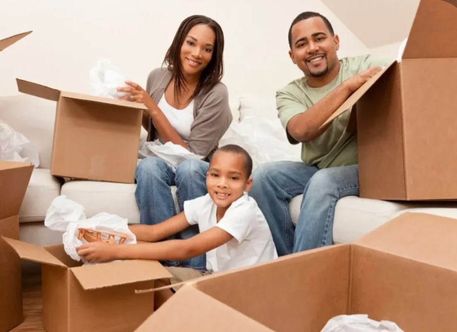family packing household items into moving boxes while organizing and decluttering their home