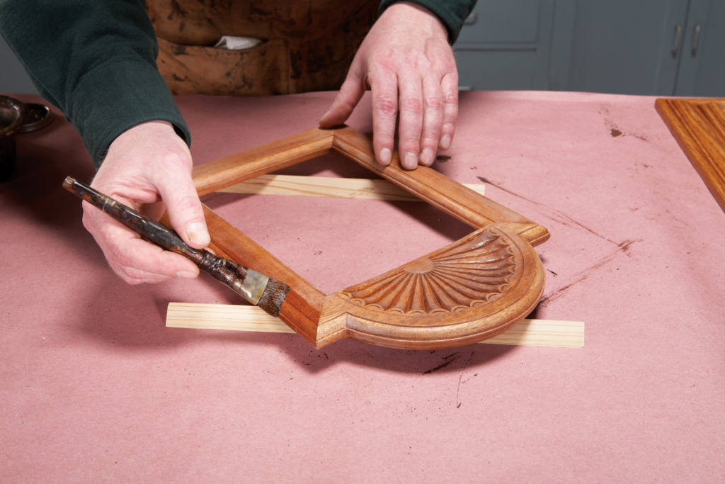 restoring and staining vintage wooden photo frame with brush