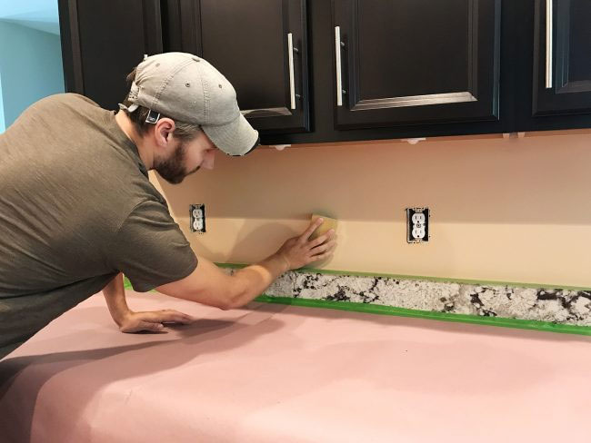 DIY kitchen backsplash prep sanding wall before tile installation