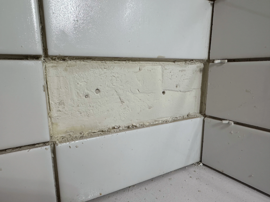 removing old kitchen backsplash tiles and cleaning wall surface for renovation