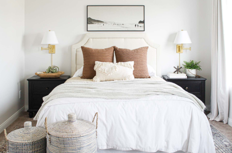 A bed with pillows and a painting above it