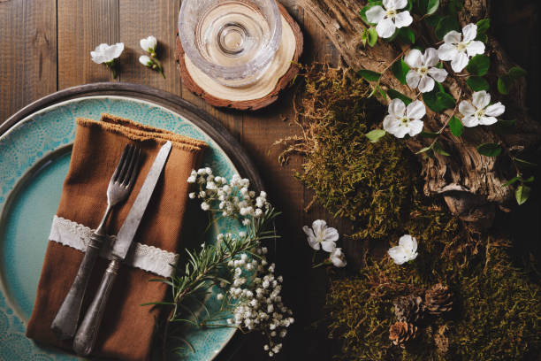 Rustic nature-themed table setting with flowers, wood, and vintage cutlery