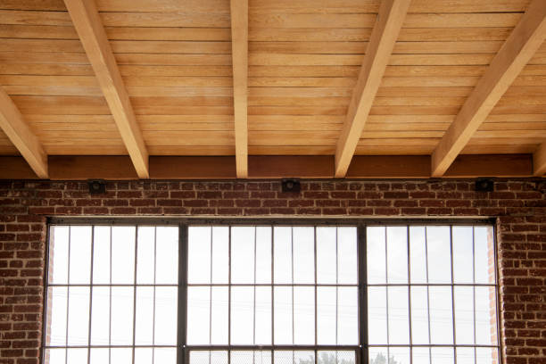 Brick and wood loft with exposed ceiling beams and large grid windows
