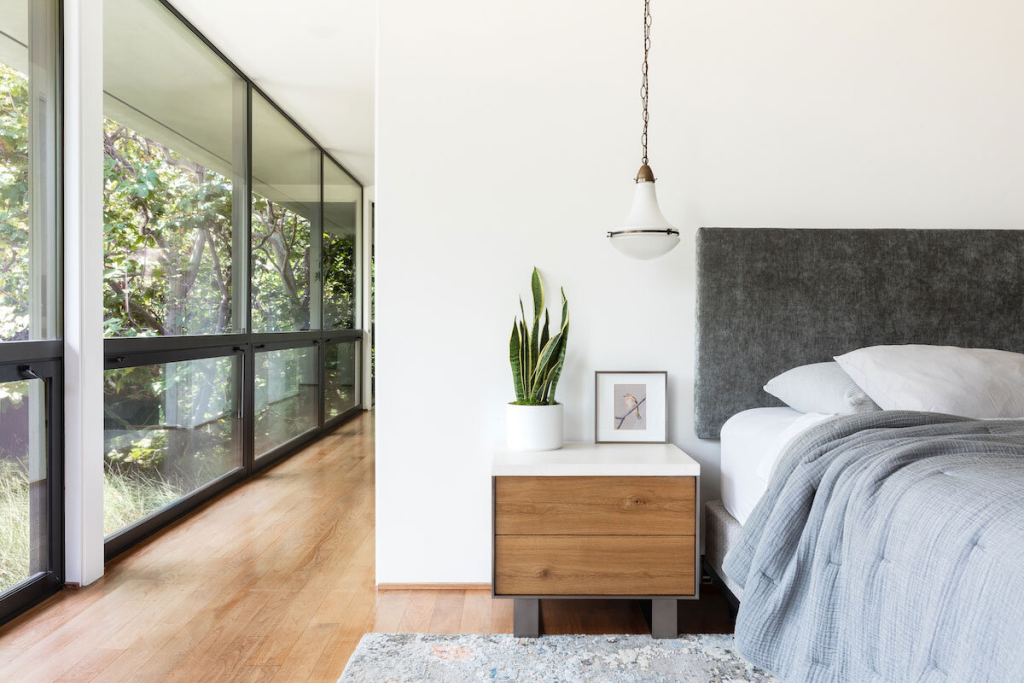 Minimalist bedroom with large glass windows and wooden floors