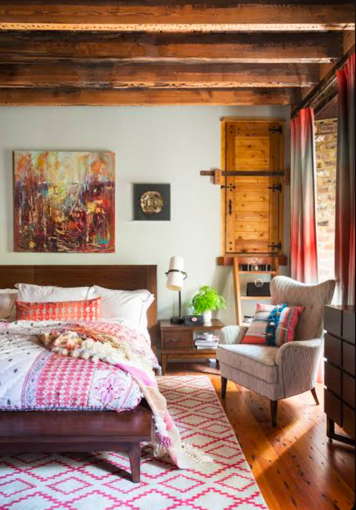 Warm rustic bedroom with wood beams and patterned rug