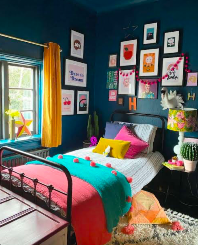 Playful bedroom with teal walls and pink pom-pom throw