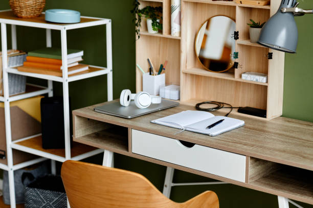 Image of busy home office workplace with wooden table and notebook set up for studying.