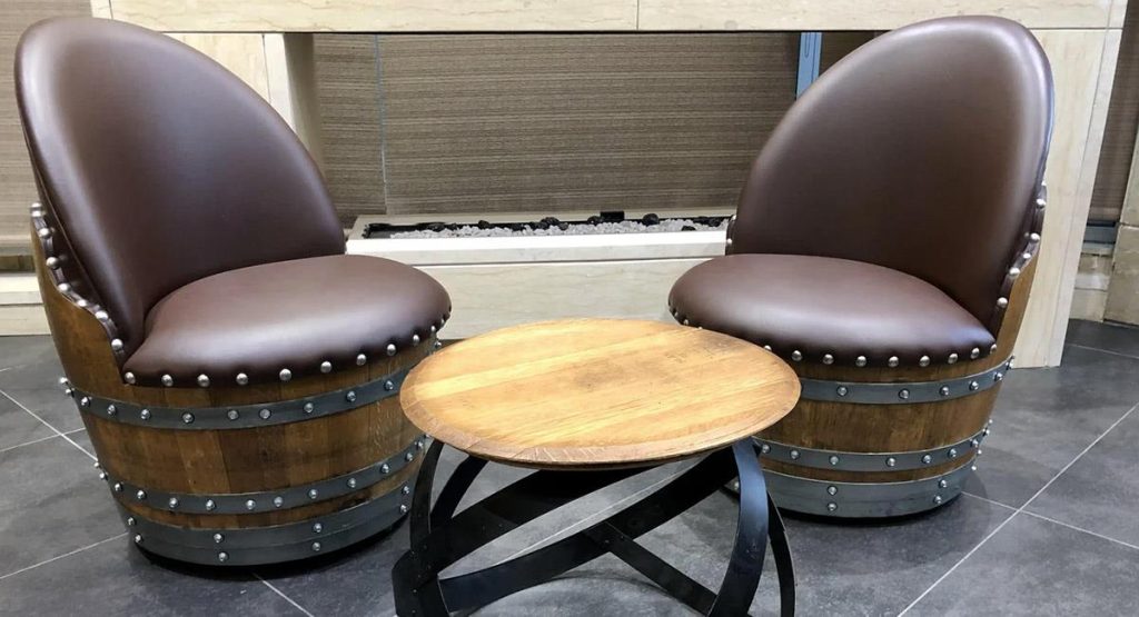 Stylish barrel chairs with leather cushions and a modern wood table.